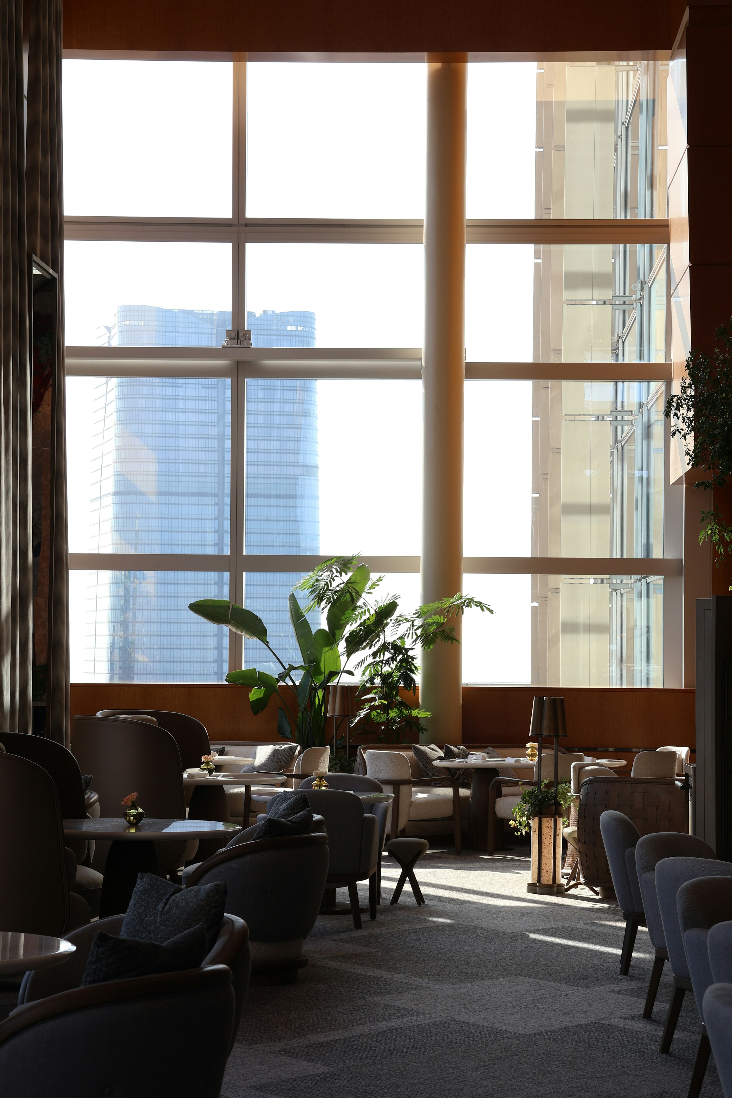 통유리창 너머 도시 타워가 보이는 조용한 호스피탈리티 라운지.