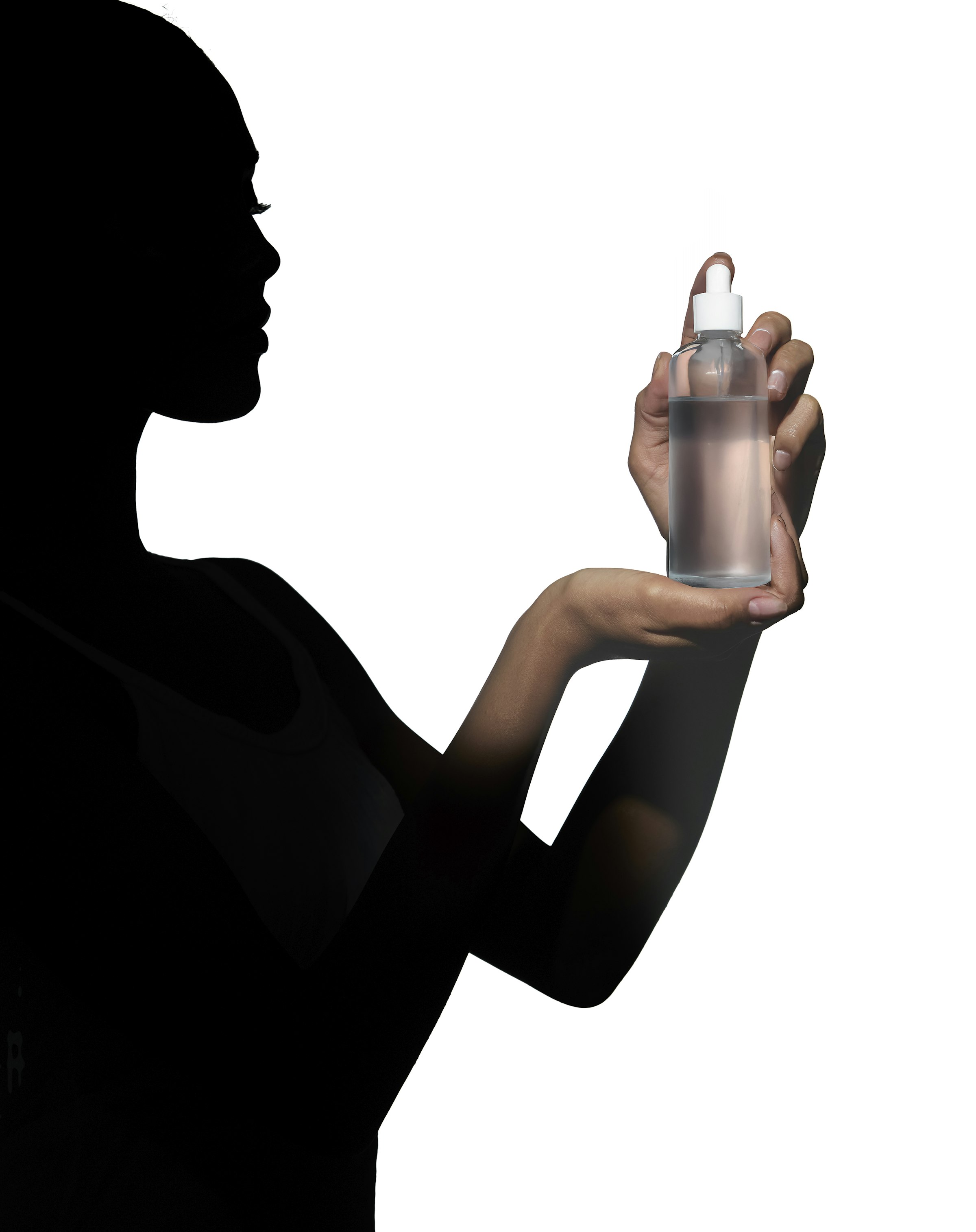 밝은 배경 앞에서 들고 있는 스킨케어 세럼 보틀.